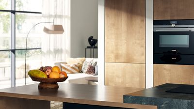 Blick in eine moderne Küche in erdigen Farben mit Küchenzeile und hochwertigen Siemens Einbaugeräten.