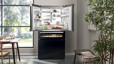 Siemens: una persona che guarda all'interno di un frigorifero a libero posizionamento pieno di cibo