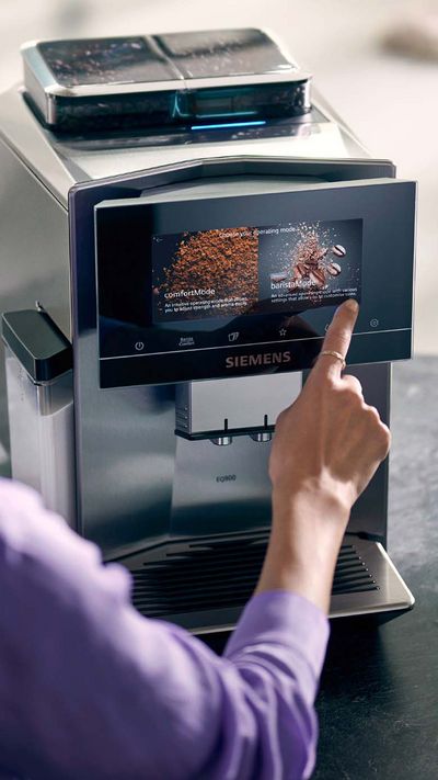 Žena vybírá režim baristaMode na dotykovém displeji kávovaru EQ900