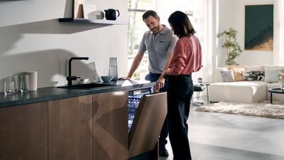 Link öffnet den Siemens Hausgeräte Service; ein Mann und eine Frau bedienen einen Siemens Geschirrspüler