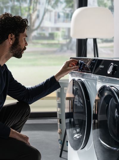 Ein Mann konfiguriert seine Siemens-Waschmaschine