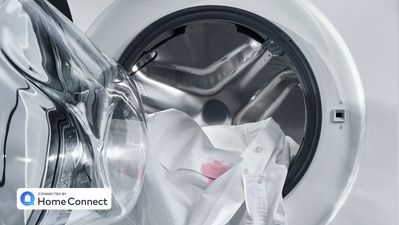 Bild på fläckiga kläder i smart tvättmaskin i smart grovkök