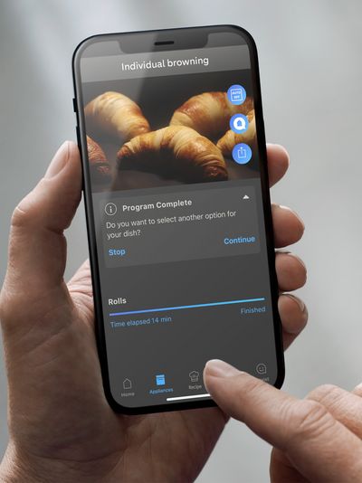 Gebruiker bekijkt op smartphone of de croissants in de slimme oven al klaar zijn.