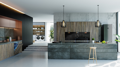 Cuisine moderne avec armoires grises élégantes, accents en bois et éclairage pendentif.