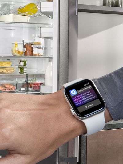 Ein Handgelenk mit einer Smartwatch, die den Türalarm für den Kühlschrank anzeigt