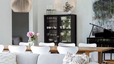 Rosa peoner på stort matbord med hvite Arne Jacobsen Syveren-stoler i stilren stue.