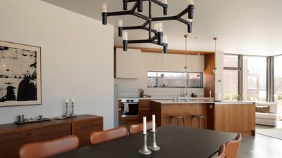 Åpen planløsning mellom kjøkken og stue. Spisebord med Arne Jacobsen Syveren-stoler kledd i skinn.