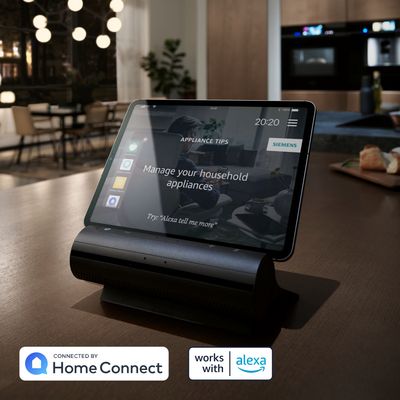 Tablet-Gerät mit "Verwalten Sie Ihre Haushaltsgeräte" Schnittstelle, verbunden mit Alexa, auf einem Tisch in einer Café-Einstellung. 