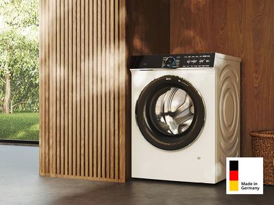 Eine Siemens Made in Germany Waschmaschine in einer Nische eines modernen Wohnraums mit Holzvertäfelung.