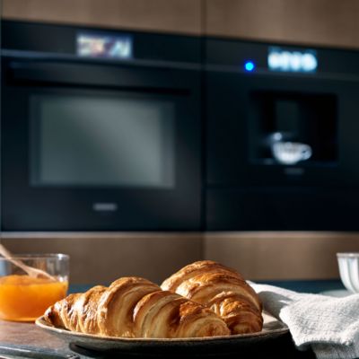 Marble table with croissant on top, and Siemens ovens in the background