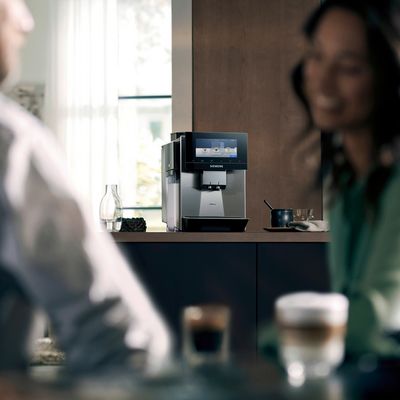 Coffee machine in the background as people chat over coffee