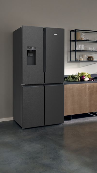 Siemesn French-Door Kühlschrank mit Gefrier-Bereich unten. Das freistehende Gerät steht in einer Küche.