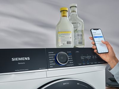 Auf einer i-Dos Waschmaschine steht Waschmittel. Daneben ist eine Hand mit Handy zu sehen. Das Waschmitteldosiersystem i-Dos gibt Waschmittel und Weichspüler auf den Milliliter genau hinzu. Mit der Siemens Hausgeräte App kann Waschmittel gescannt werden und du weißt genau den Verbrauch.