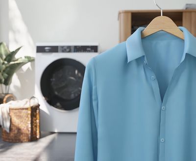 Im Vordergrund ist ein faltenfreies Hemd auf einem Bügel hängend zu sehen. Im Hintergrund sieht man ein Siemens Wäschepflegegerät.