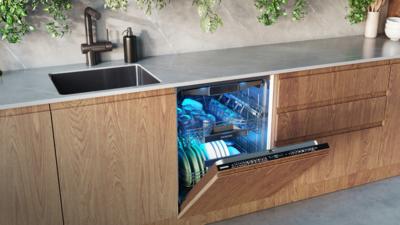 Ein Mann lädt Geschirr in einen Siemens-Geschirrspüler in einer modernen Küche.