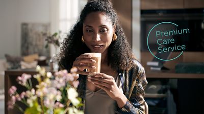 Kvinde nyder en varm drik, promoverer Premium Care Service. 