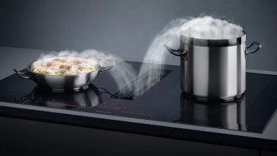 Una padella e una pentola su un elegante piano di cottura a induzione nero.