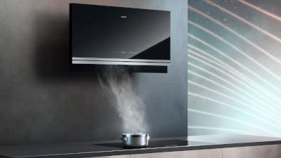 TV nera montato a parete, vapore che sale da pentola sul contatore qui sotto.