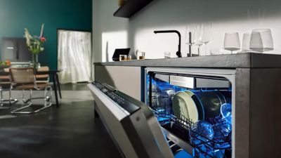 Una cucina moderna è caratterizzata da una lavastoviglie parzialmente aperta, che mostra piatti puliti e interni illuminati.