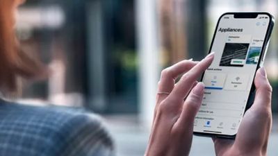 Una persona tiene in mano uno smartphone che visualizza un'applicazione mobile incentrata sugli elettrodomestici.