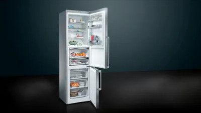 Un moderno frigorifero verticale con porta aperta, che mostra scaffali ordinati e pieni di cibo e bevande su uno sfondo scuro.