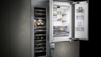 Frigorifero moderno con porta aperta, un portabottiglie e compartimenti di stoccaggio a risparmio energetico.