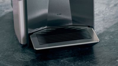 Gros plan sur la cuvette d'égouttage d'une machine à café Siemens en acier inoxydable.