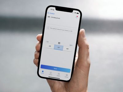 Een hand die een smartphone vasthoudt met het gedeelte maalgraadinstellingen van de Siemens Home Appliances-app weergegeven op het scherm.