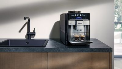 Une machine expresso automatique Siemens sur le comptoir de la cuisine avec deux tasses expresso.