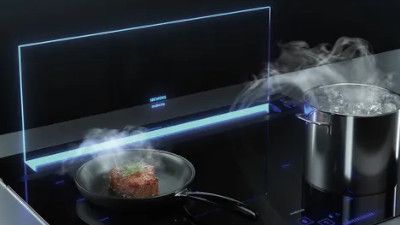 Elettrodomestico da cucina con fumo e cucina su una superficie di vetro.
