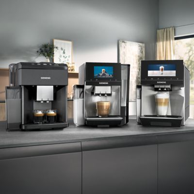         Tre forskjellige Siemens helautomatiske kaffemaskiner på en kjøkkenbenk med ulike kaffedrikker.       