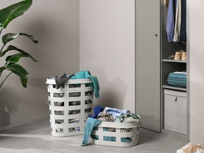 Deux paniers remplis de linge de diff&eacute;rentes couleurs sont pr&ecirc;ts &agrave; &ecirc;tre lav&eacute;s.