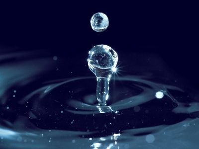 Trois gouttes d'eau sont suspendues dans l'air.