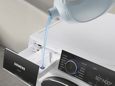 Detersivo versato con attenzione nel cassetto di una lavatrice.