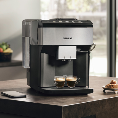 Une machine à café Siemens sur un comptoir en bois avec deux expressos sous le distributeur.