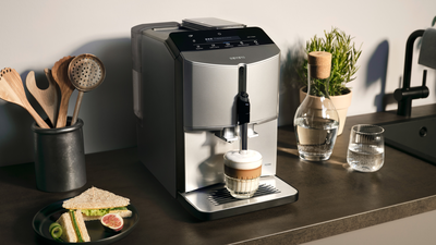 Une machine à café Siemens fait mousser le lait dans un latte macchiato avec sa buse à lait.