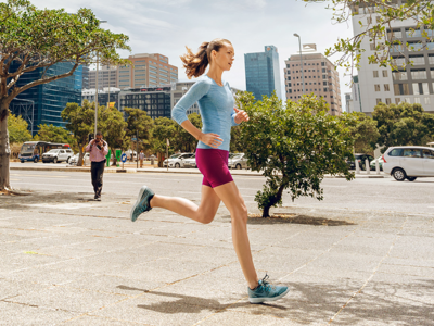 Een sportieve vrouw rent in een stedelijke omgeving.
