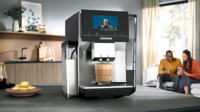 Une machine &agrave; caf&eacute; Siemens est en train de servir un caf&eacute;, pos&eacute;e sur le plan de travail d'une cuisine moderne.