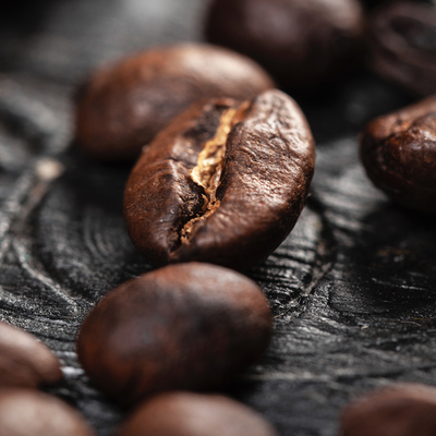 Gebrande koffiebonen op een donker werkblad.