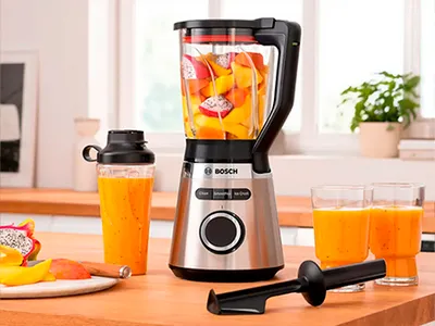 Bosch Blender VitaPower Serie 4 with fruits, To-Go-bottle and smoothie glasses on a kitchen shelf.