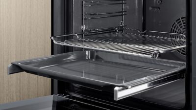 Een foto van een open Siemens-oven met twee bakplaten die gedeeltelijk uitgeschoven zijn, ter demonstratie van de flexibiliteit van de telescopische geleiders.   