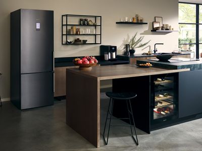 Cucina moderna ed elegante con elettrodomestici da incasso Siemens, tra cui un frigorifero, una cantinetta e una macchina da caffè. Il design aperto e i materiali di alta qualità creano un’atmosfera sofisticata.