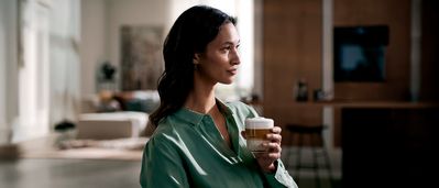 Kvinna som dricker en kopp kaffe.