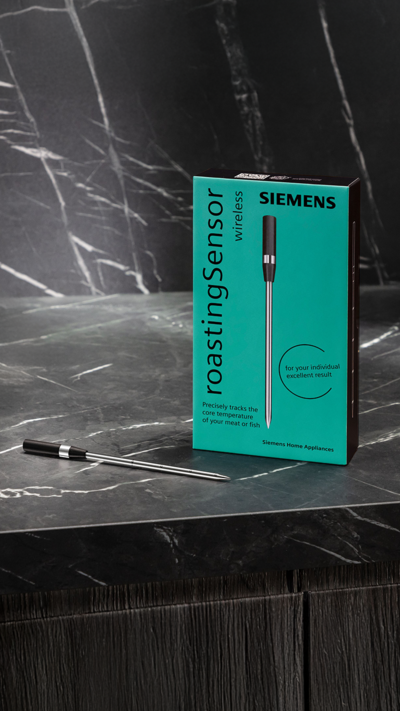 Bezprzewodowa termosonda marki Siemens na ciemnoszarym marmurowym blacie obok opakowania produktu.