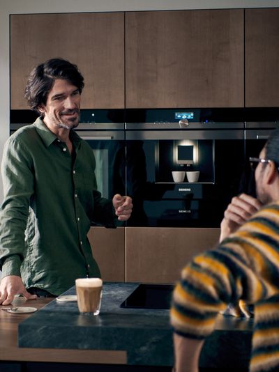 Il link apre le Siemens Home Stories su architettura e interior design; un uomo in una cucina componibile di design
