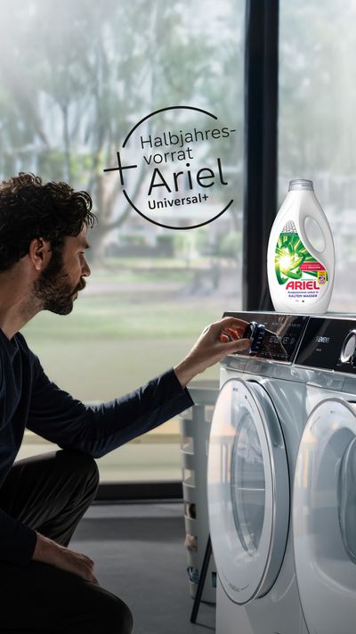 Mann laden Waschmaschine mit Ariel Universal+ Waschmittel vor Fenster mit Ariel Logo.