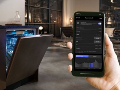 HomeWizard-app op smartphone met op de achtergrond een vaatwasser