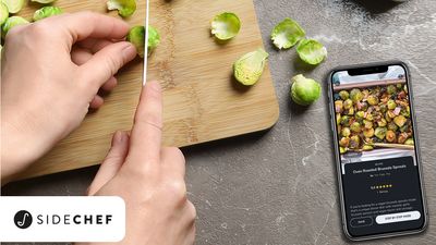 Hand snijdt spruitjes, telefoon toont SideChef-recept voor geroosterde spruitjes.