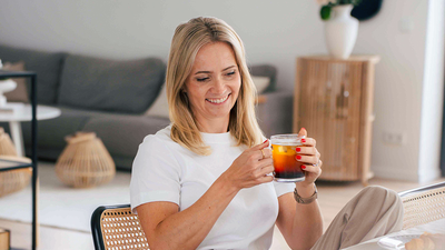 Une femme dégustant son café froid servi dans un verre.