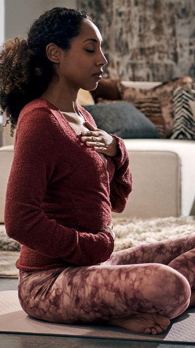 Woman doing yoga breathing in a living room